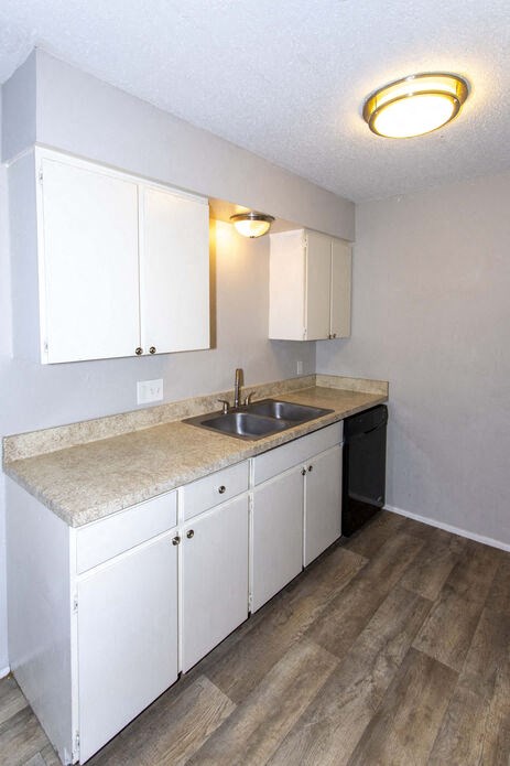 an empty kitchen with white cabinets and a sink