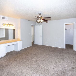 an empty living room with a ceiling fan