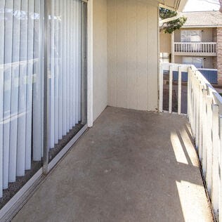 a porch with a white fence and a glass door