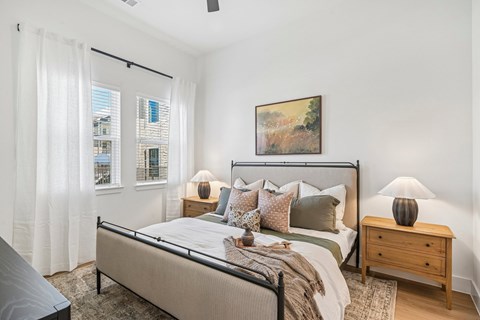 A bedroom with a large bed, a nightstand, and a painting on the wall.