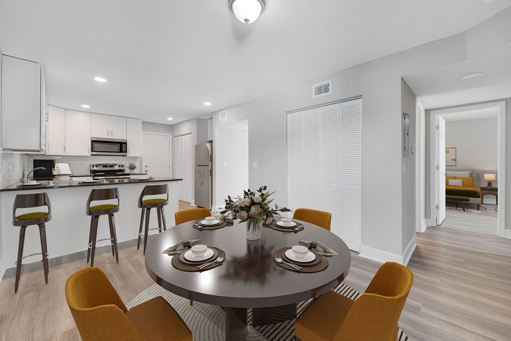 a dining room and kitchen with a table and chairs