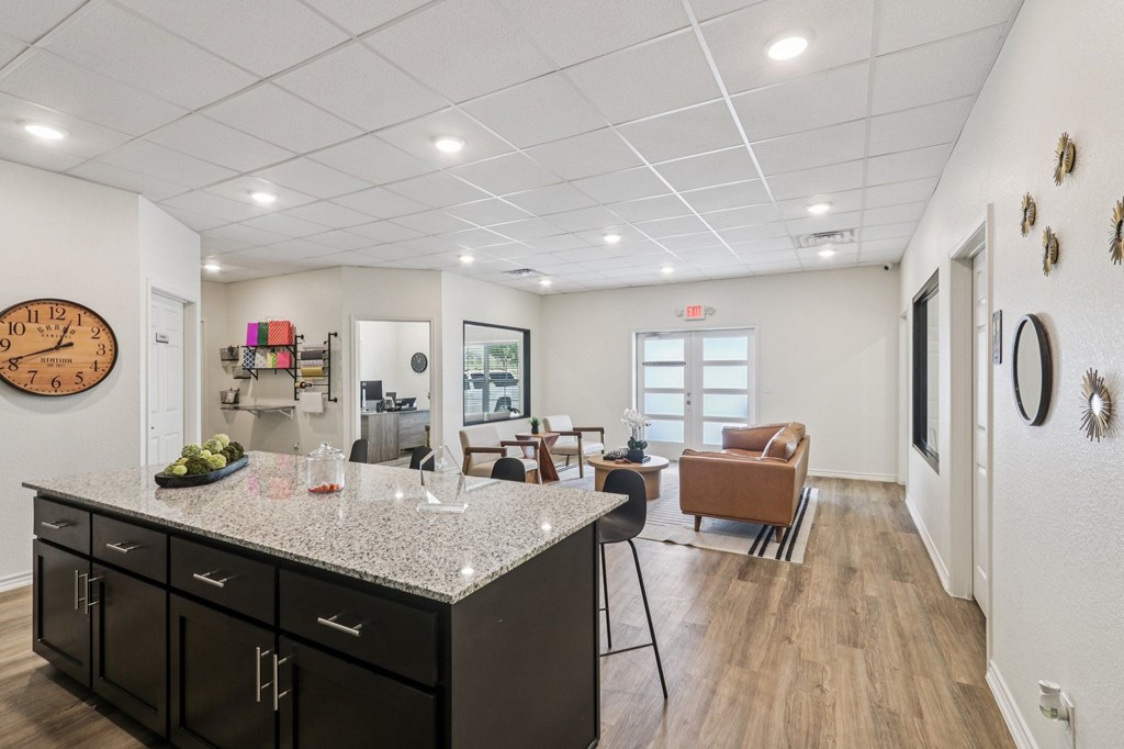 A kitchen with a granite countertop and black cabinets.