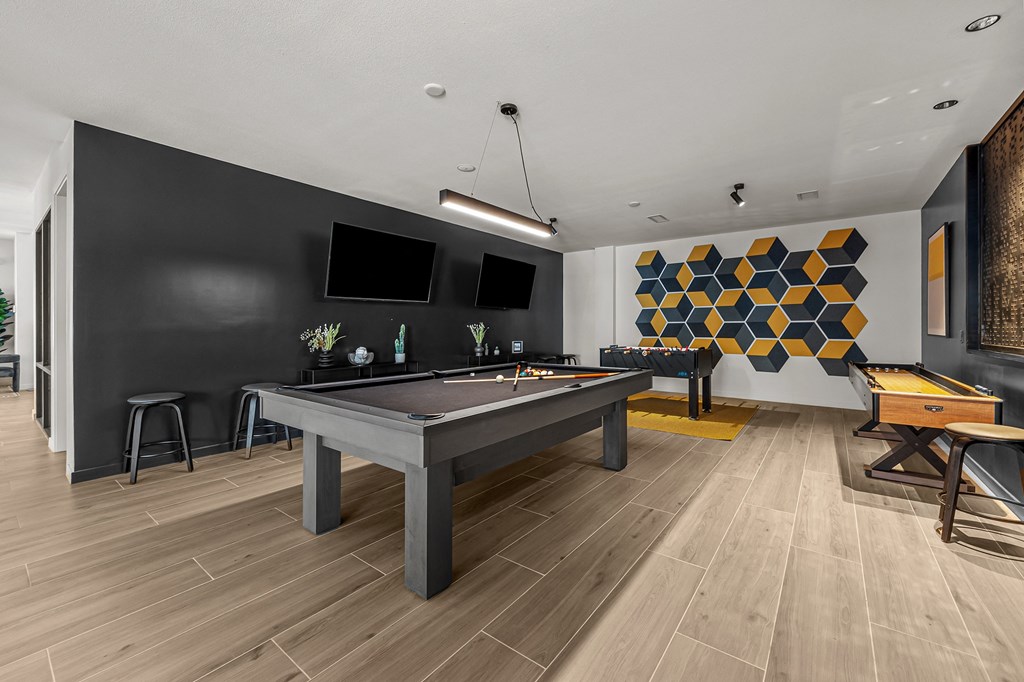a games room with a pool table and a television