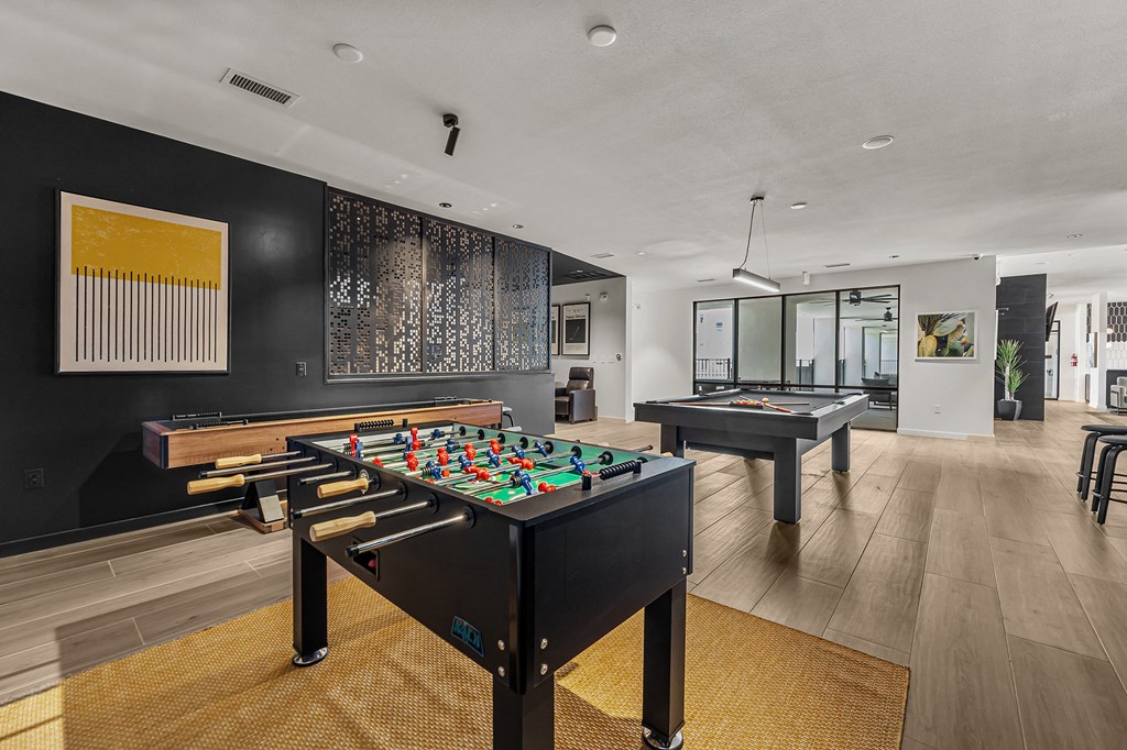 a game room with two pool tables and a billiards table