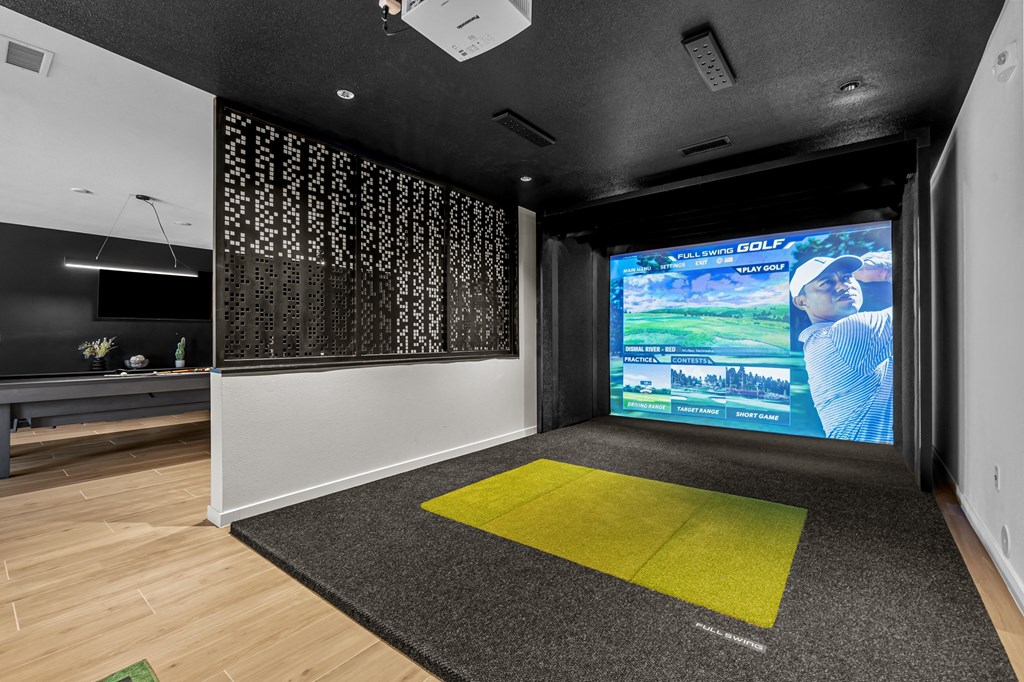 a living room with a large screen on the wall and a yellow rug