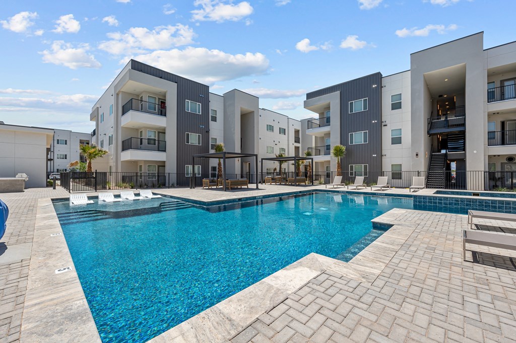 a swimming pool with apartment buildings in the background