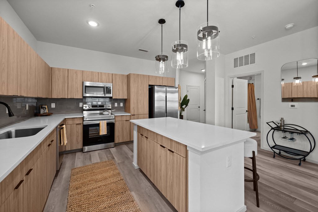 a white kitchen with wooden cabinets and stainless steel appliances