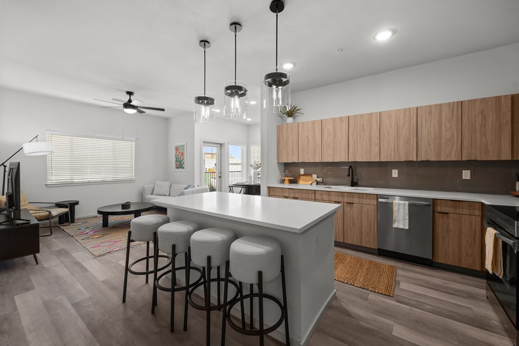 a kitchen with a large island and stools in a living room