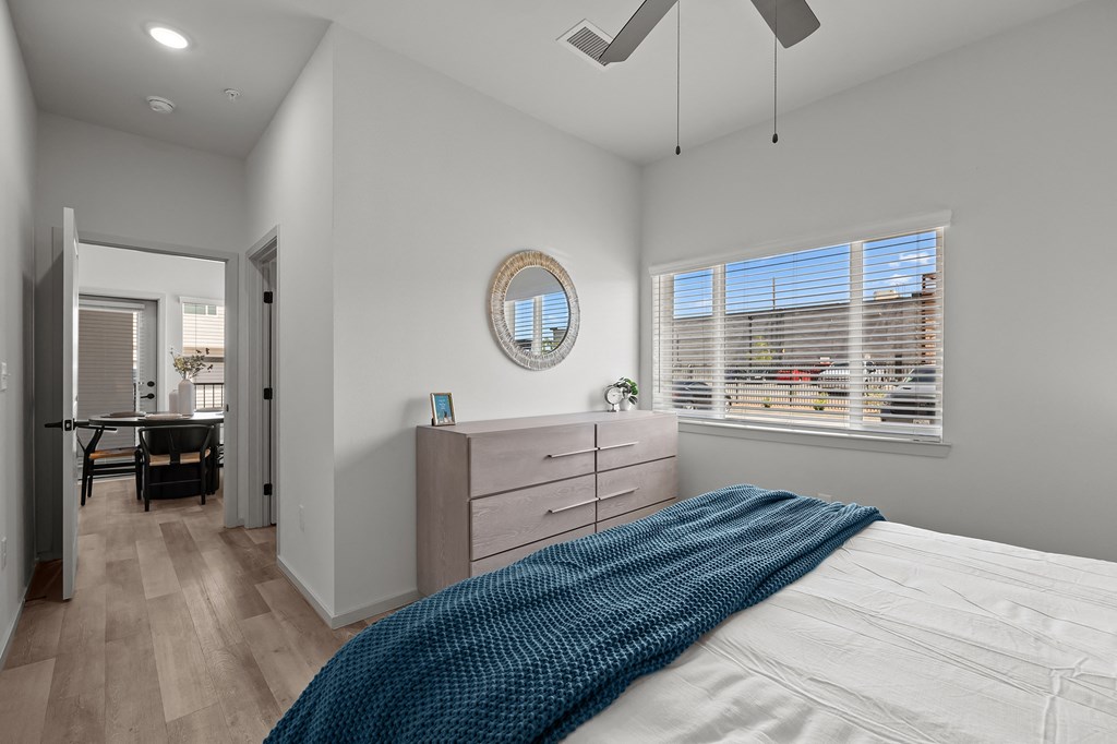 a bedroom with a bed and a dresser and a window