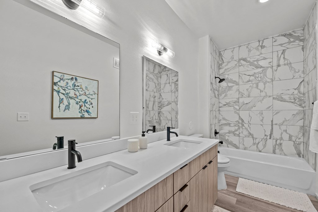 a bathroom with two sinks and a shower and a tub
