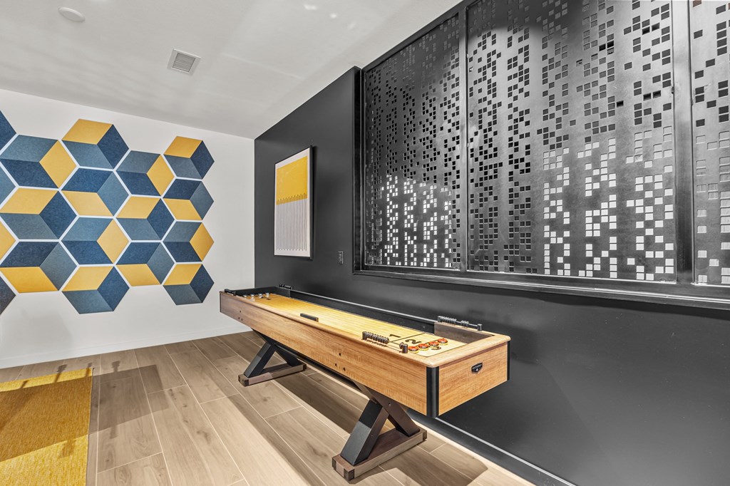 a games room with a wooden table and a wall with a large scoreboard