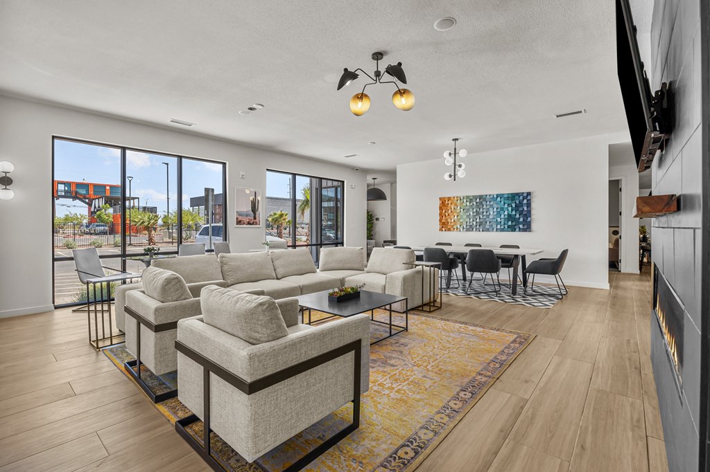 a living room with a couch and a coffee table and a dining room with chairs