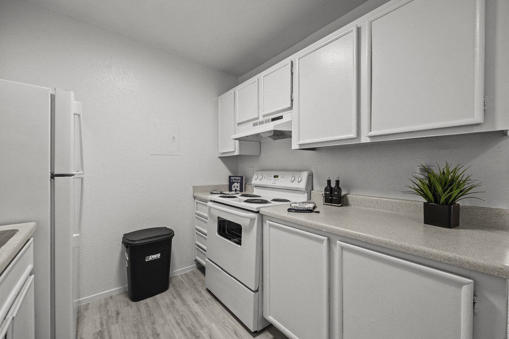 A small kitchen with white appliances and cabinets.