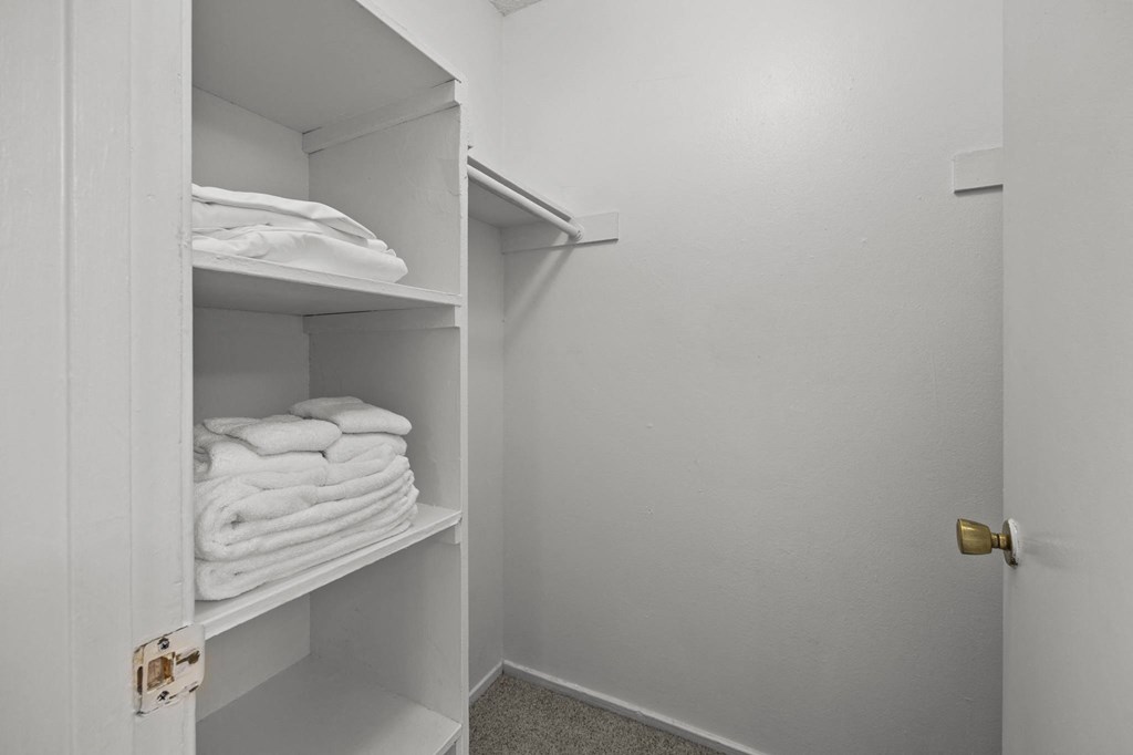 A white cabinet with towels on shelves.