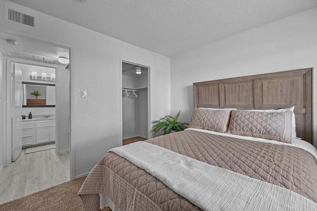 A bedroom with a large bed and a mirrored closet.