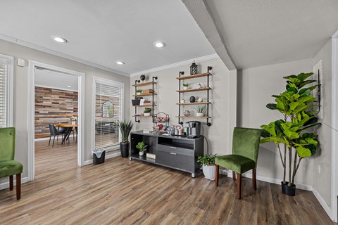 a living room with white walls and a wooden floor and a black entertainment center