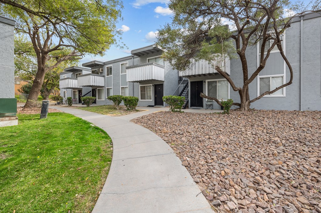 A residential area with apartment buildings and a sidewalk.