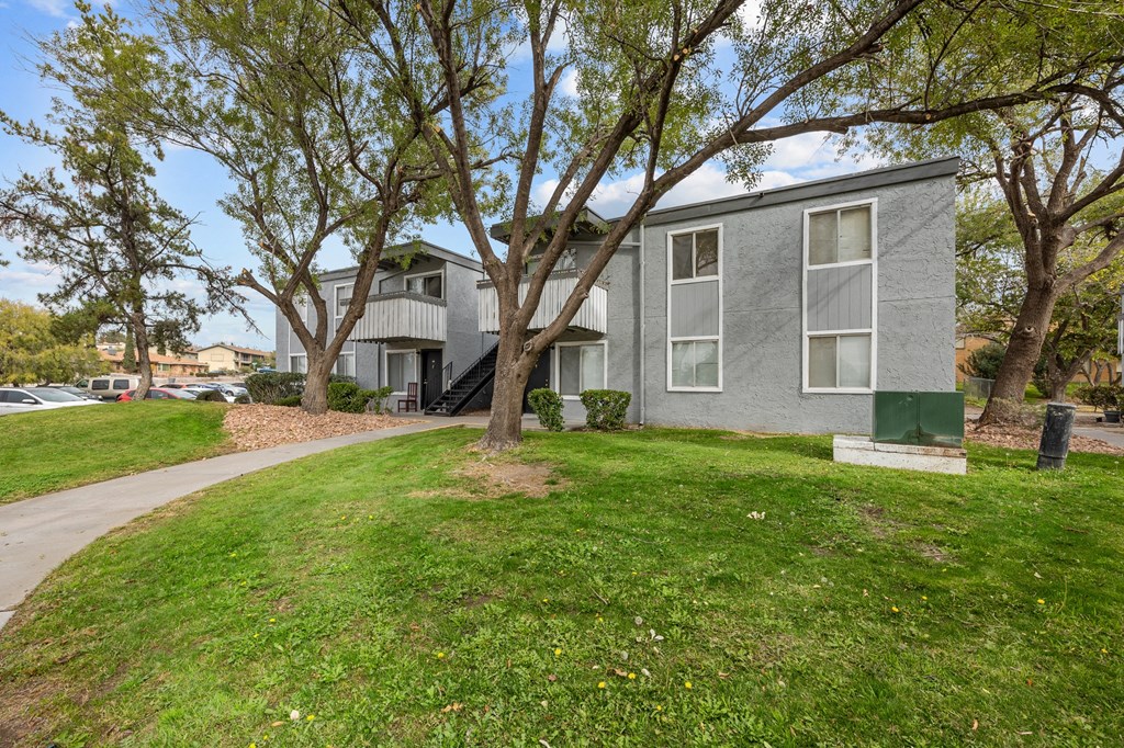 A grey building with a green post box in front.