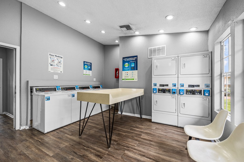 a laundry room with two washes and a table with two chairs