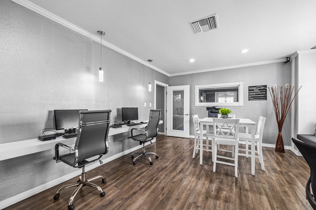 a home office with a dining table and chairs and a desk with a chair