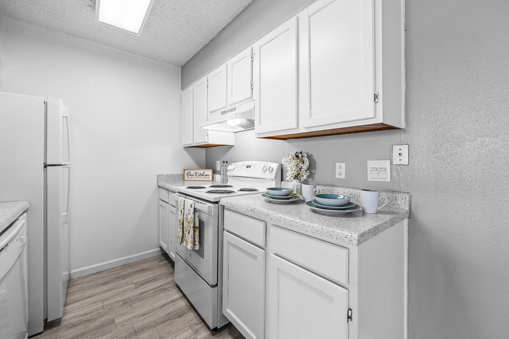 a white kitchen with white cabinets and a white refrigerator