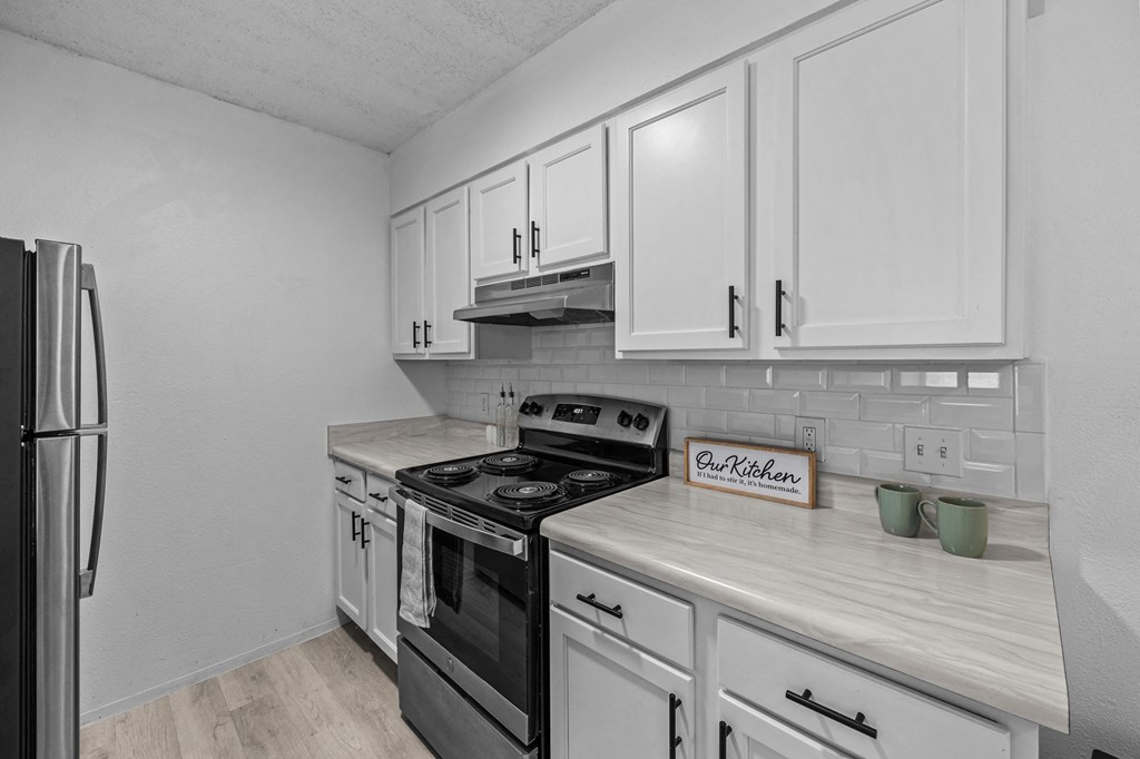 a kitchen with white cabinets and a stove and a refrigerator