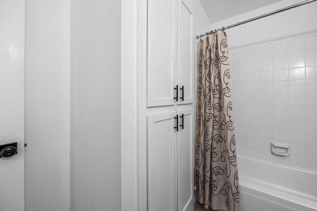 a bathroom with a shower and a white door