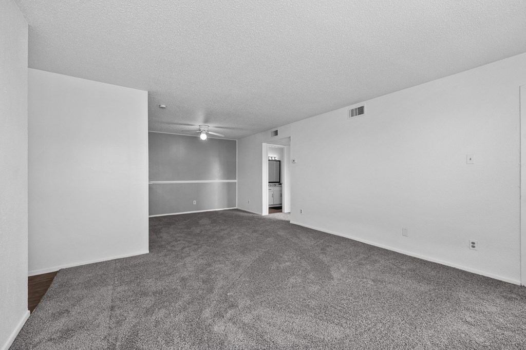 an empty living room with carpet and white walls