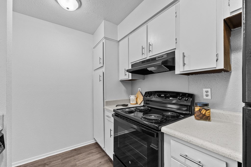 a kitchen with white cabinets and a black stove