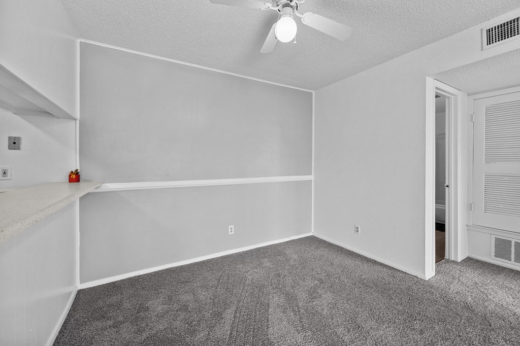 the living room of a manufactured home with carpet and a ceiling fan