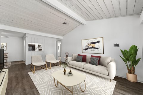 A living room with a white couch, a coffee table, and a painting on the wall.