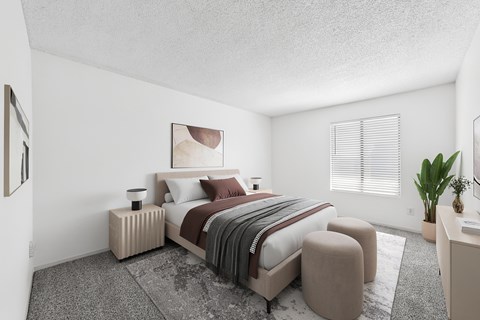 A bedroom with a large bed and a small table with a plant on it.