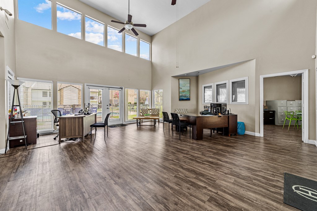 A room with a ceiling fan and a table with chairs.