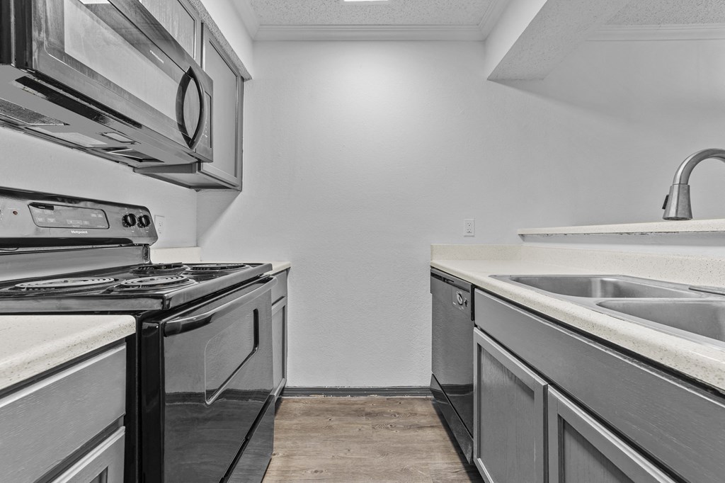 A modern kitchen with a stove, oven, and sink.