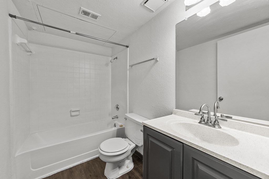 A white bathroom with a toilet, sink, and bathtub.