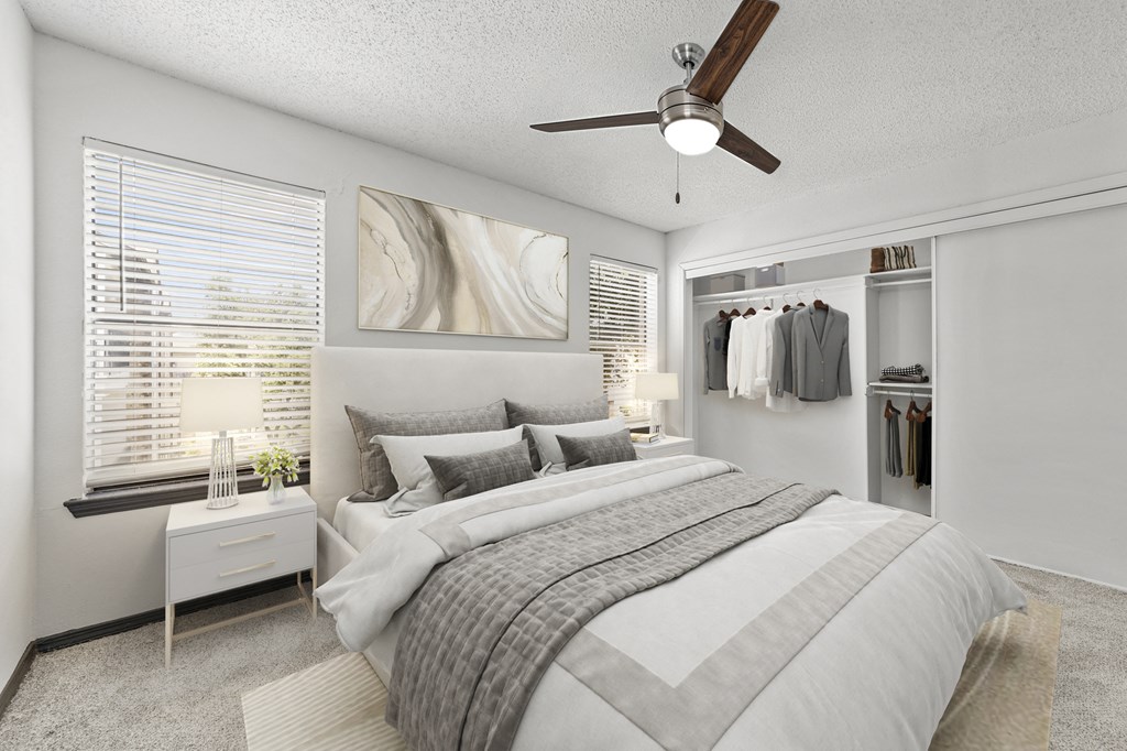 A bedroom with a large bed and a ceiling fan.
