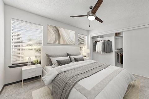 A bedroom with a large bed and a ceiling fan.