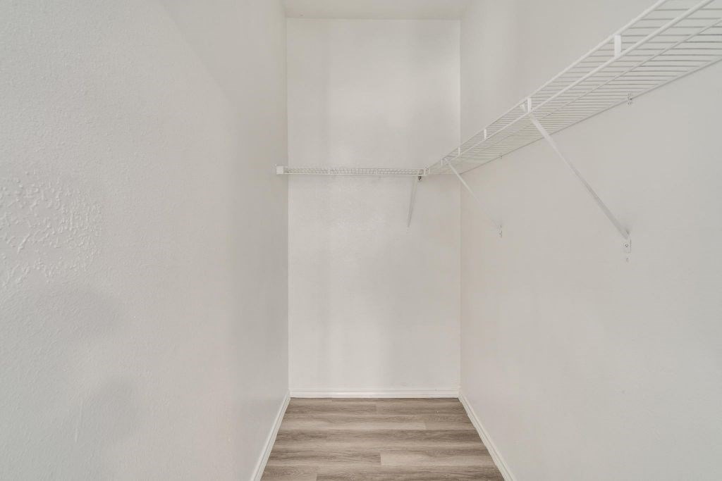 an empty room with white walls and a wood floor