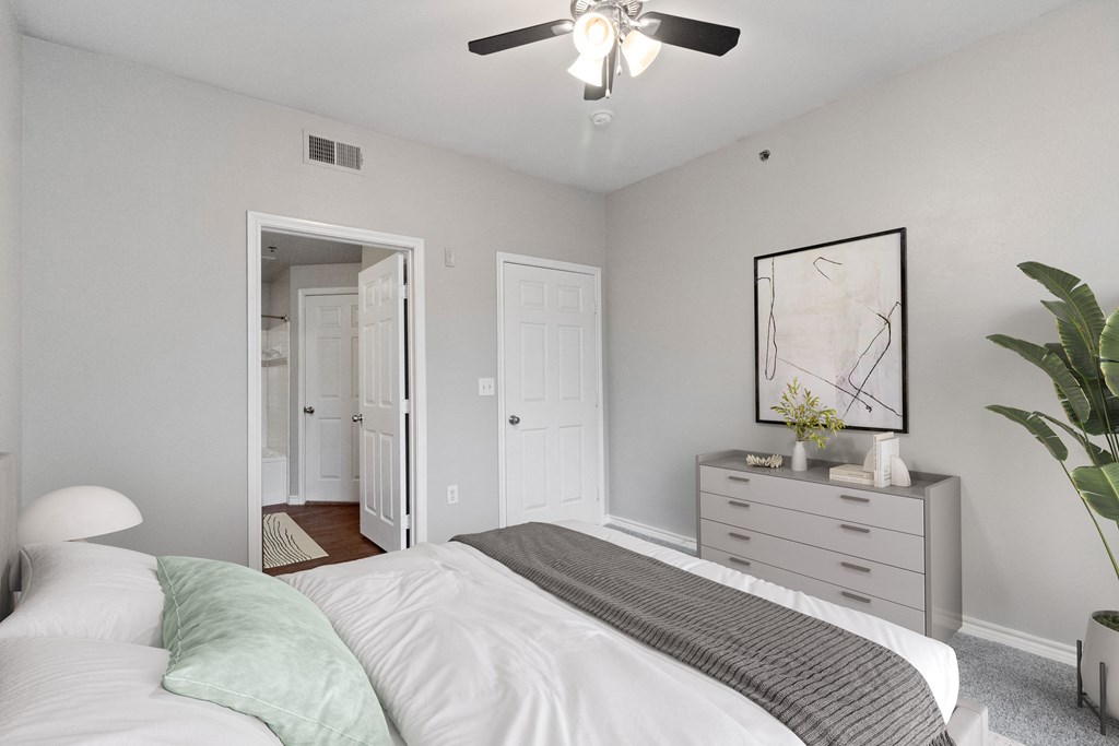an empty bedroom with a bed and a ceiling fan