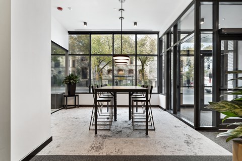 a dining room with a table and chairs and floor to ceiling windows