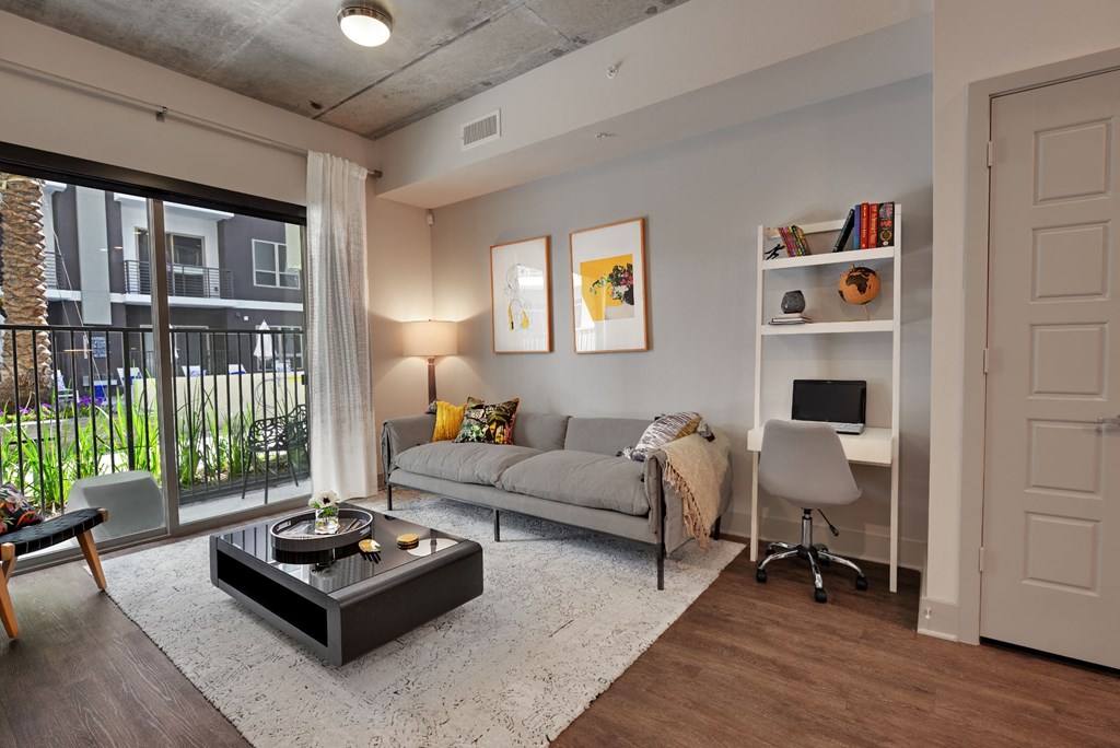 a living room with a couch and a coffee table in front of a large window