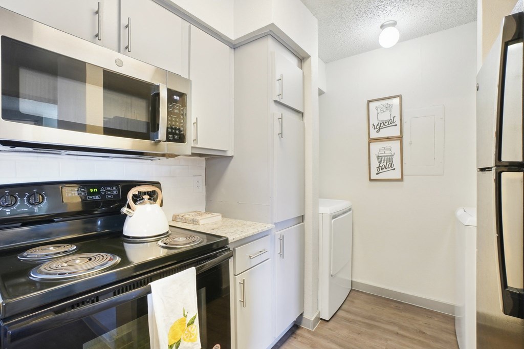 A kitchen with a stove, microwave, and refrigerator.