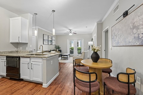 A kitchen with a table and chairs in front of a window.