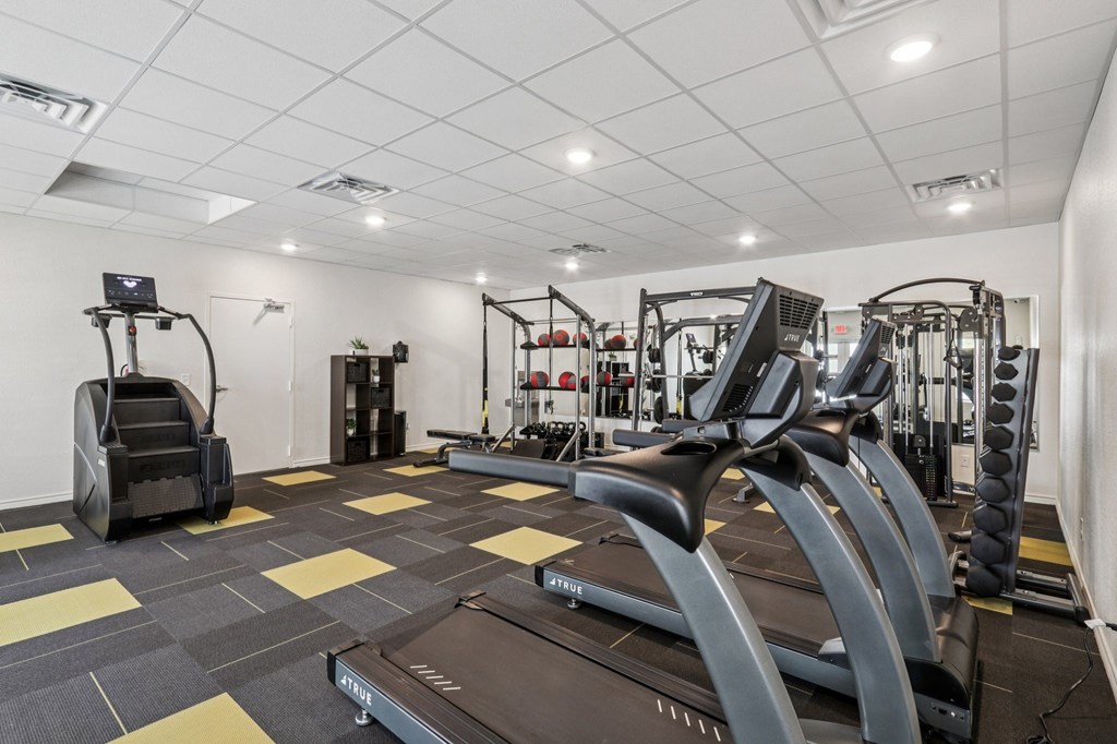 A treadmill is in the middle of a gym with other exercise equipment.