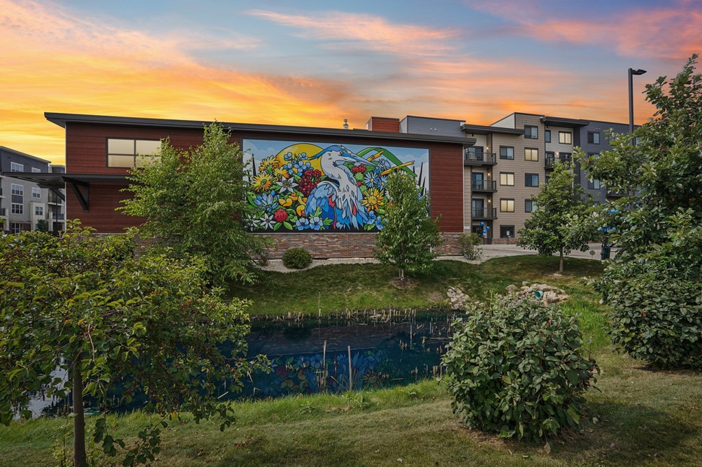 A mural on a building is visible from a grassy area.