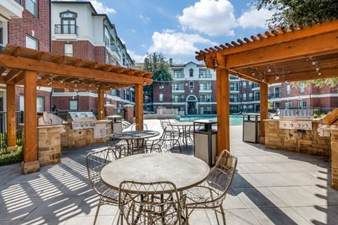 an outdoor patio with tables and chairs and a pool