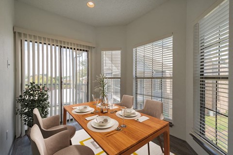 a dining room with a wooden table and chairs
