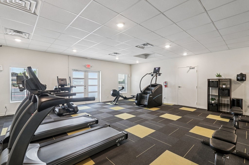 A gym with treadmills, elliptical machines, and other exercise equipment.