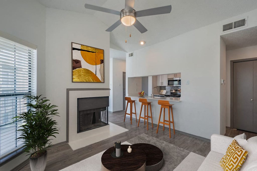 a living room with a fireplace and a bar with stools