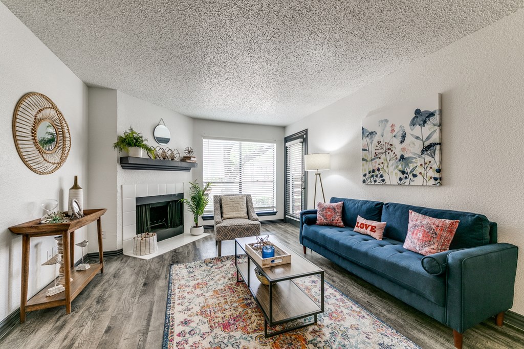 the living room of an apartment with a blue couch and a fireplace
